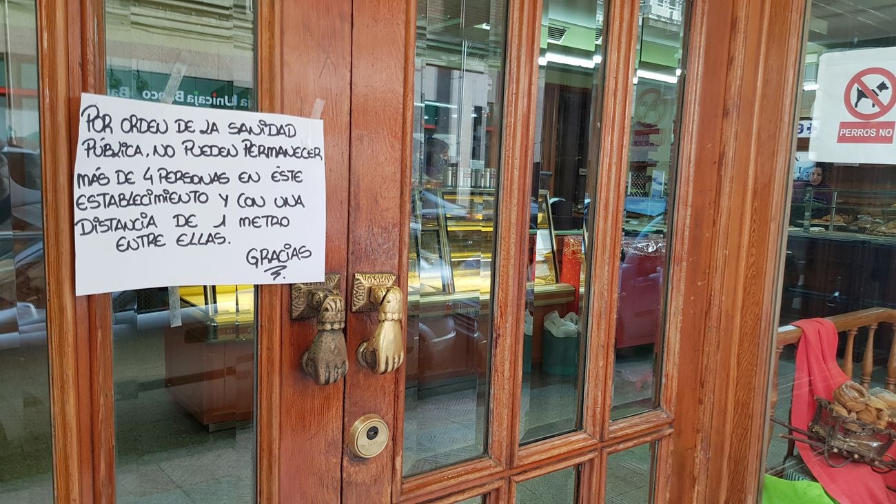 Un cartel anuncia la necesidad de mantener la distancia de seguridad en un comercio.