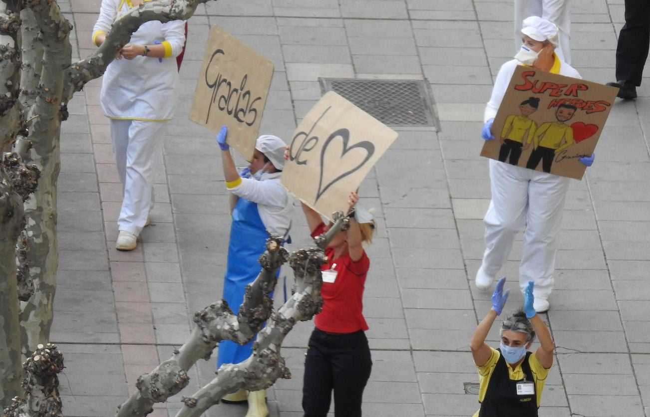 Trabajadores de los supermercados en la barriada de Eras de Renueva salen a la calle para aplaudir a los vecinos. Corazones y gratitud al aire para animar a los residentes en el duro confinamiento.