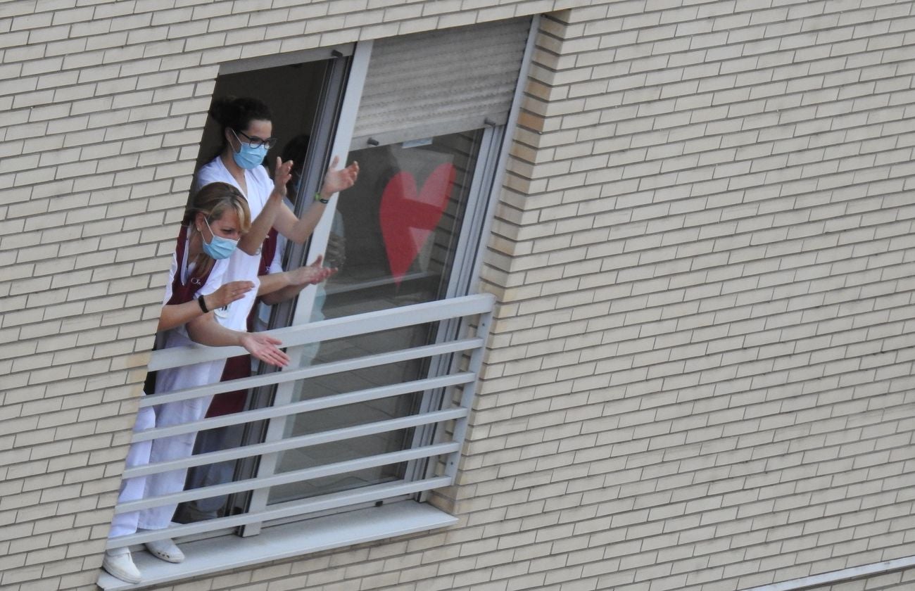 Trabajadores de los supermercados en la barriada de Eras de Renueva salen a la calle para aplaudir a los vecinos. Corazones y gratitud al aire para animar a los residentes en el duro confinamiento.