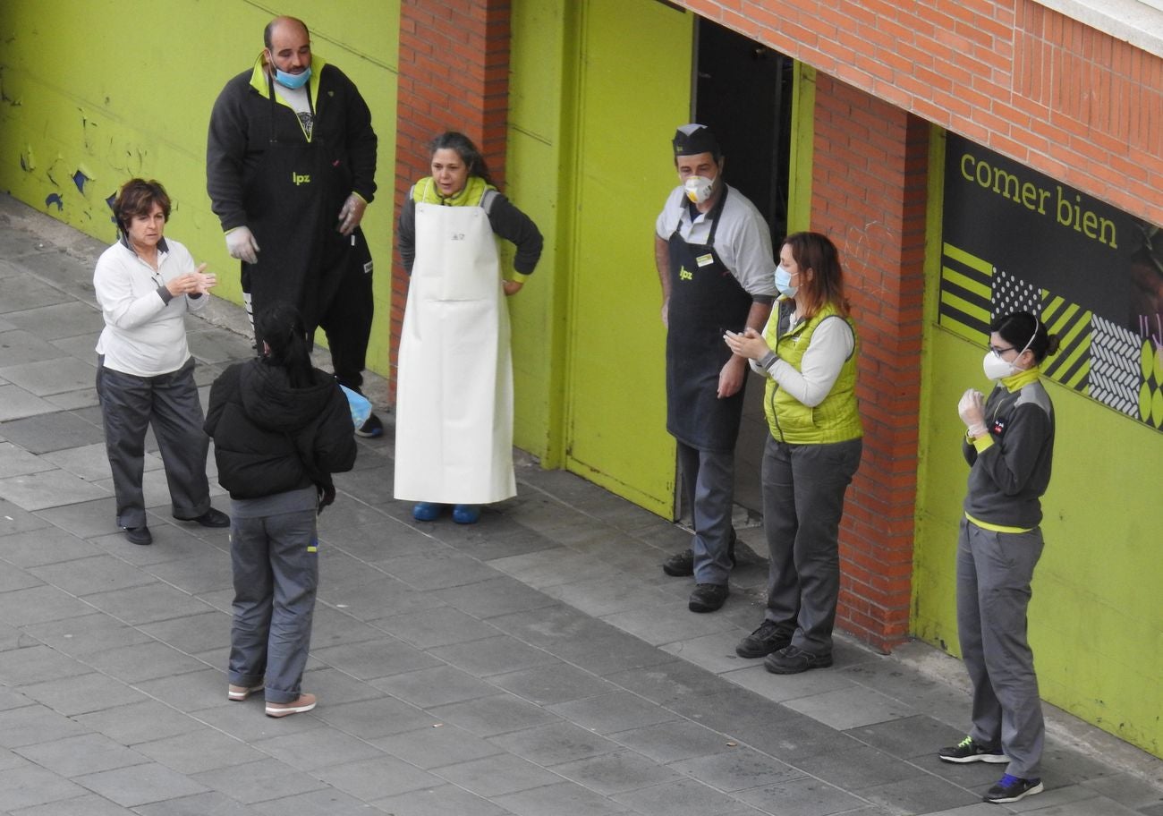 Trabajadores de los supermercados en la barriada de Eras de Renueva salen a la calle para aplaudir a los vecinos. Corazones y gratitud al aire para animar a los residentes en el duro confinamiento.