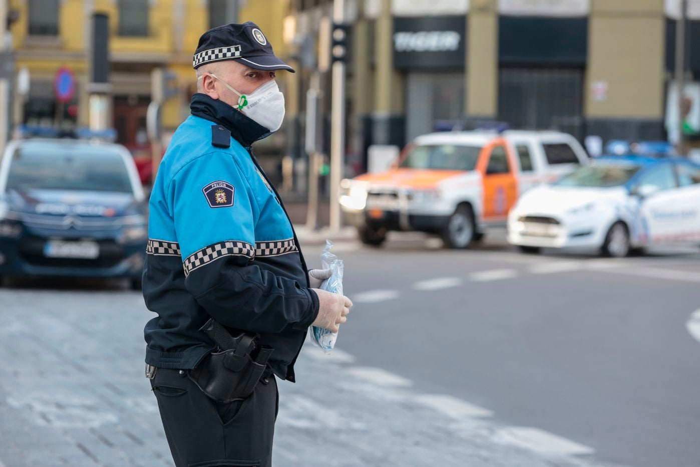 Miembros de Policía Local, Policía Nacional y Protección Civil de León, reparten mascarillas a usuarios del transporte público.