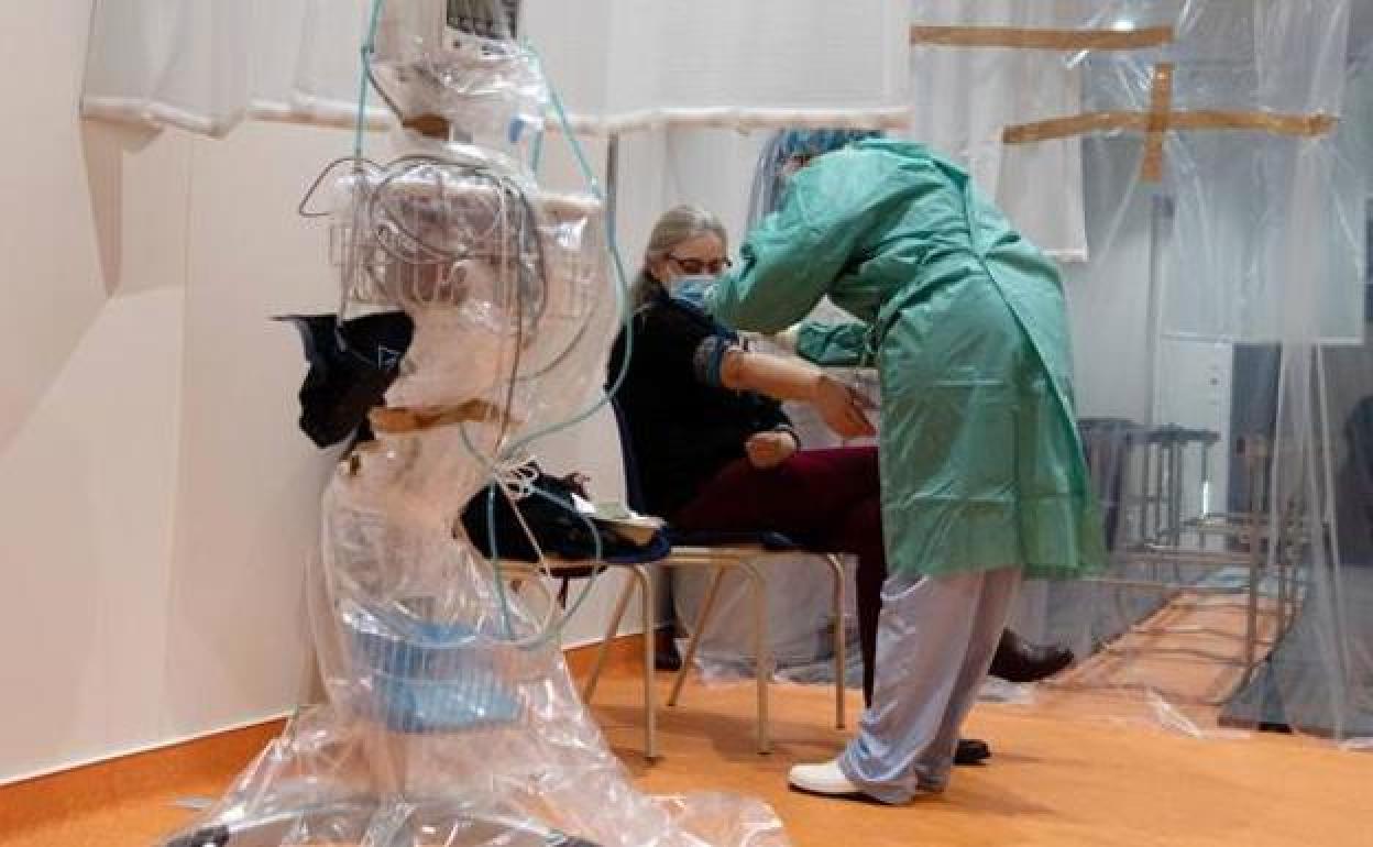 Un sanitario atiende a una paciente en una imagen de archivo.