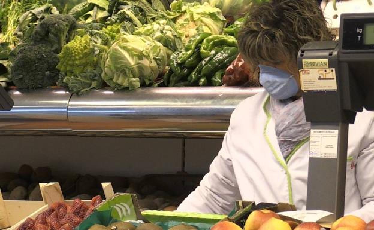 Una mujer atiende en su frutería en el mercado del Conde Luna. 