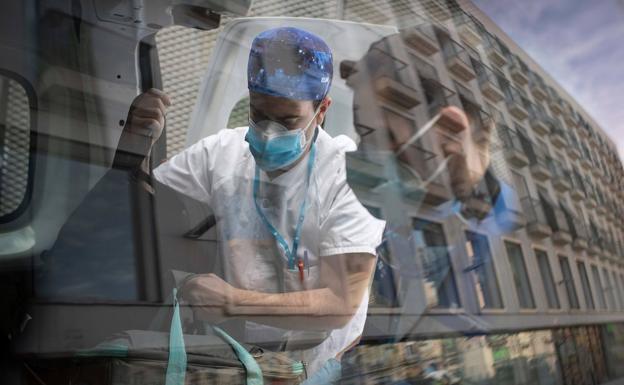 Dos sanitarios sacan material de una ambulancia. 