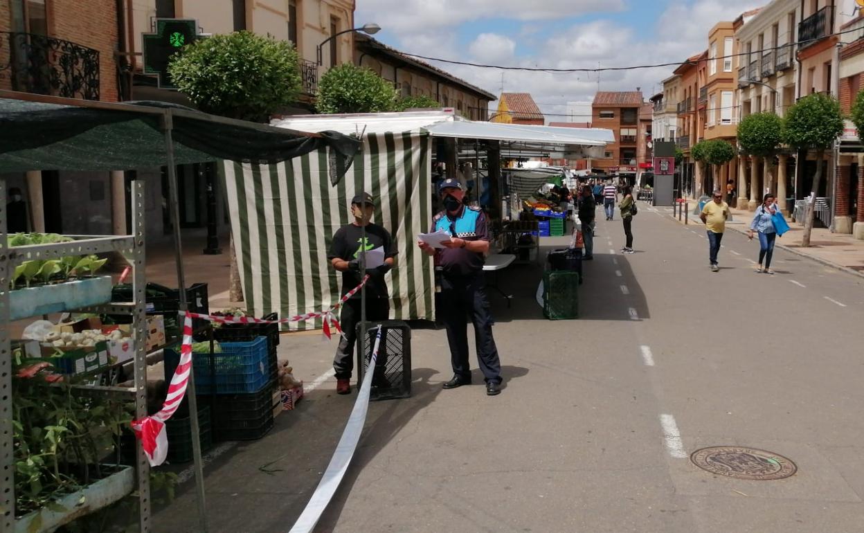 Un policía charla con un vendedor del mercado de Sahagún. 