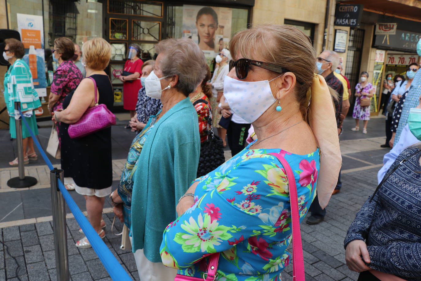 Unas mujeres reciben la comunión mientras portan mascarillas.