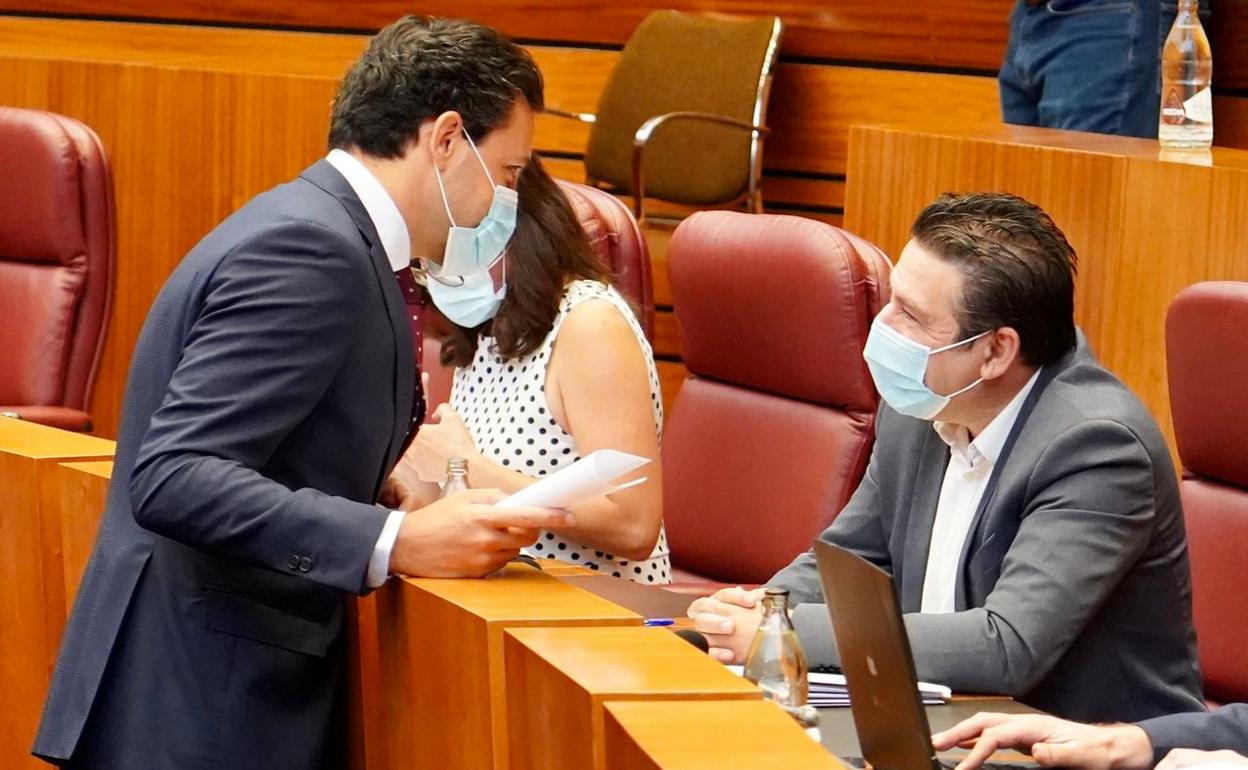 El portavoz del Grupo Popular en las Cortes, Raúl de la Hoz, conversa con el procurador de la UPL, Luis Mariano Santos, durante la segunda sesión del debate de política general de la Junta de Castilla y León en las Cortes. 