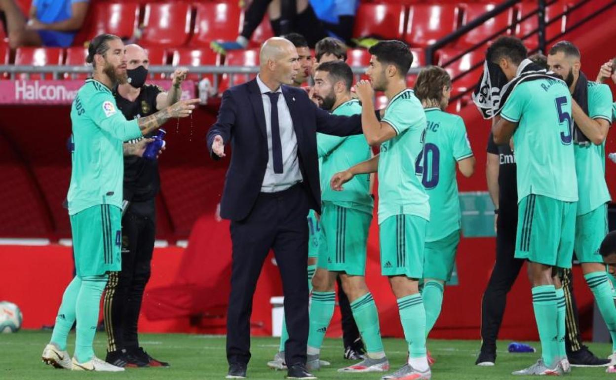 Zidane habla con sus futbolistas en una pausa de hidratación ante el Granada. 