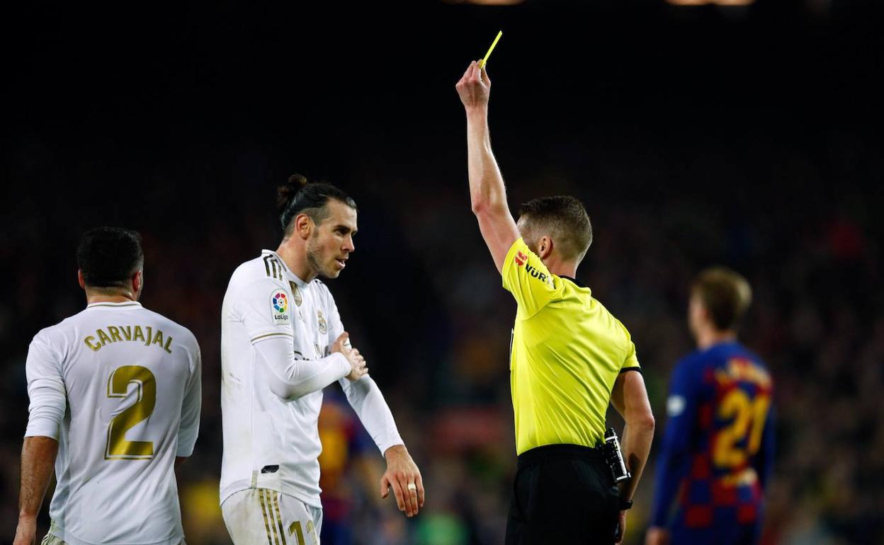 El árbitro Hernández Hernández muestra la amarilla a Bale en un Barcelona-Real Madrid. 