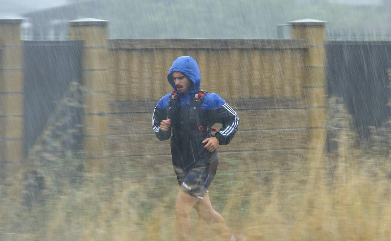 Un joven realiza deporte bajo la lluvia en Ponferrada. 