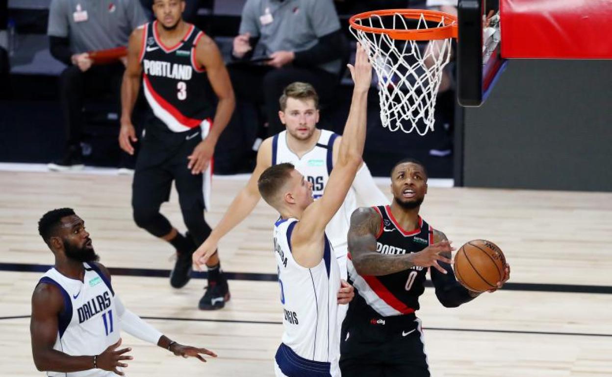 Damian Lillard penetra a canasta ante la defensa de los Mavericks.