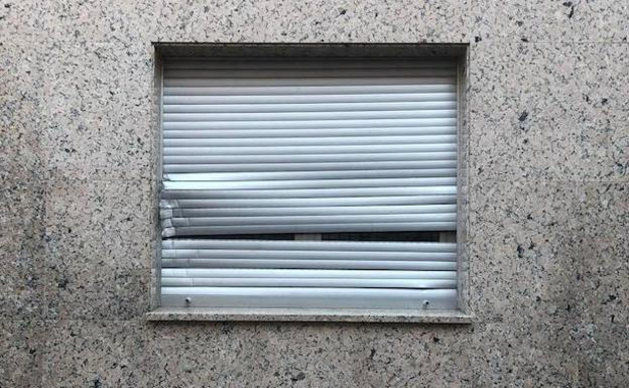 Ventana destartalada perteneciente a una vivienda 'okupada'. 