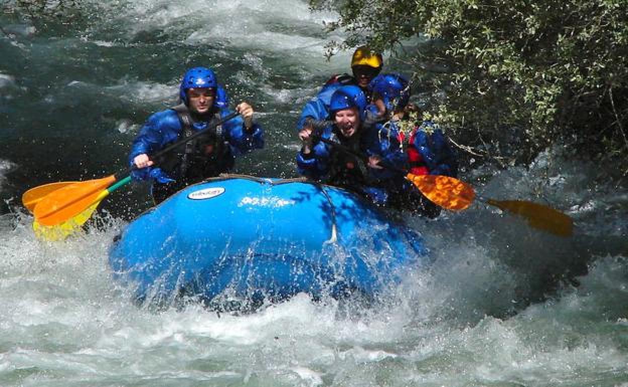 Un grupo de personas practica rafting. 
