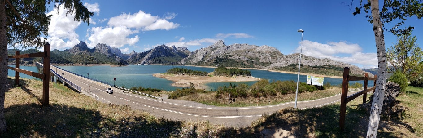 Ubicado junto a la Ermita de Nuestra Señora, en Riaño, el banco ofrece unas privilegiadas vistas sobre el pantano y Picos | El entorno, con las viejas campanas y un 'horreo leonés', completa un escenario idílico. 