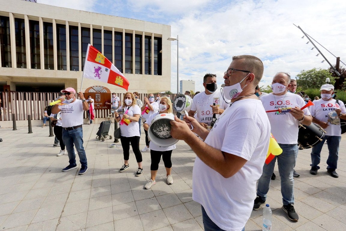 El líder autonómico socialista, Luis Tudanca, y el procurador José Luis Vázquez, conversan con el portavoz del colectivo de feriantes que ha protagonizado una cacerolada ante las Cortes de Castilla y León. 