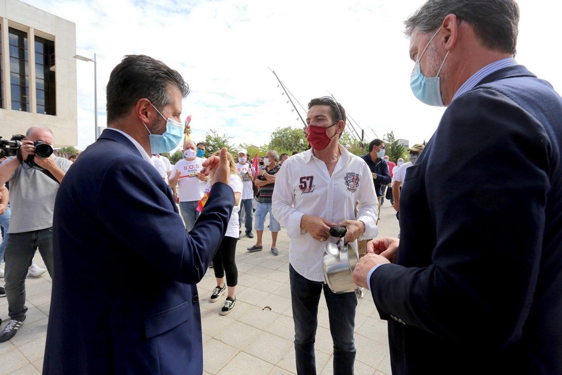 El líder autonómico socialista, Luis Tudanca, y el procurador José Luis Vázquez, conversan con el portavoz del colectivo de feriantes que ha protagonizado una cacerolada ante las Cortes de Castilla y León. 