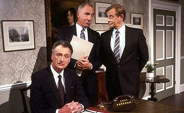 Las serie 'Yes, prime minister' con sir Humphrey, de pie con un documento.