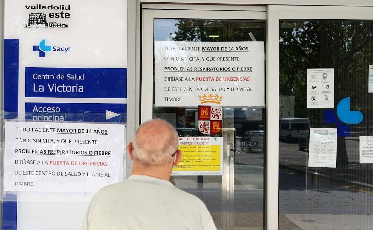 Un hombre observa los carteles de un consultorio de salud.