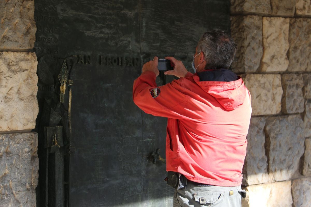 La romería de San Froilán más atípica concentra a algunos fieles a la puerta de la Basílica de la Virgen del Camino.