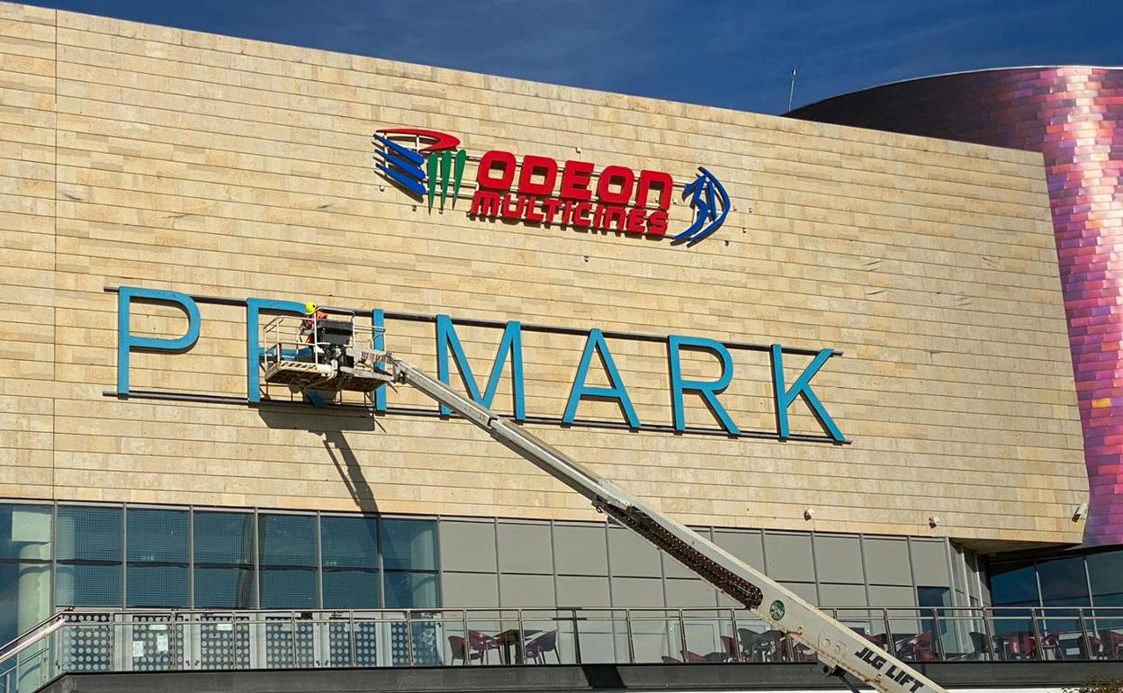 Un grupo de operarios, este viernes, durante la instalación de los carteles anunciadores de la firma Primark.