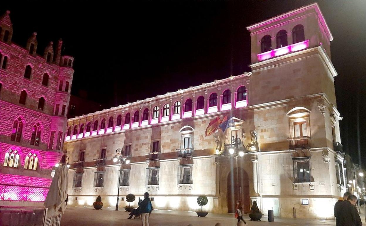 Imagen del edificio Botines y la Diputación de León iluminados con el color rosa.