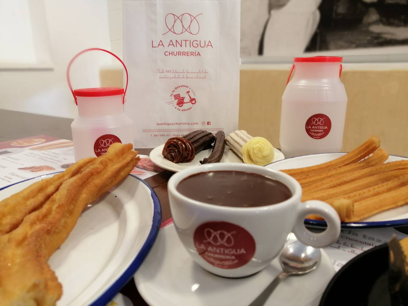 La churrería, situada en la plaza de la Inmaculada en la capital leonesa, ofrece un cuidado menú de desayunos y meriendas, donde además del plato estrella hay muchas opciones | A través de la app de Glovo o del teléfono 987 03 68 71 los leoneses pueden realizar sus pedidos con opción: recogida en local, reparto a domicilio o al lugar de trabajo