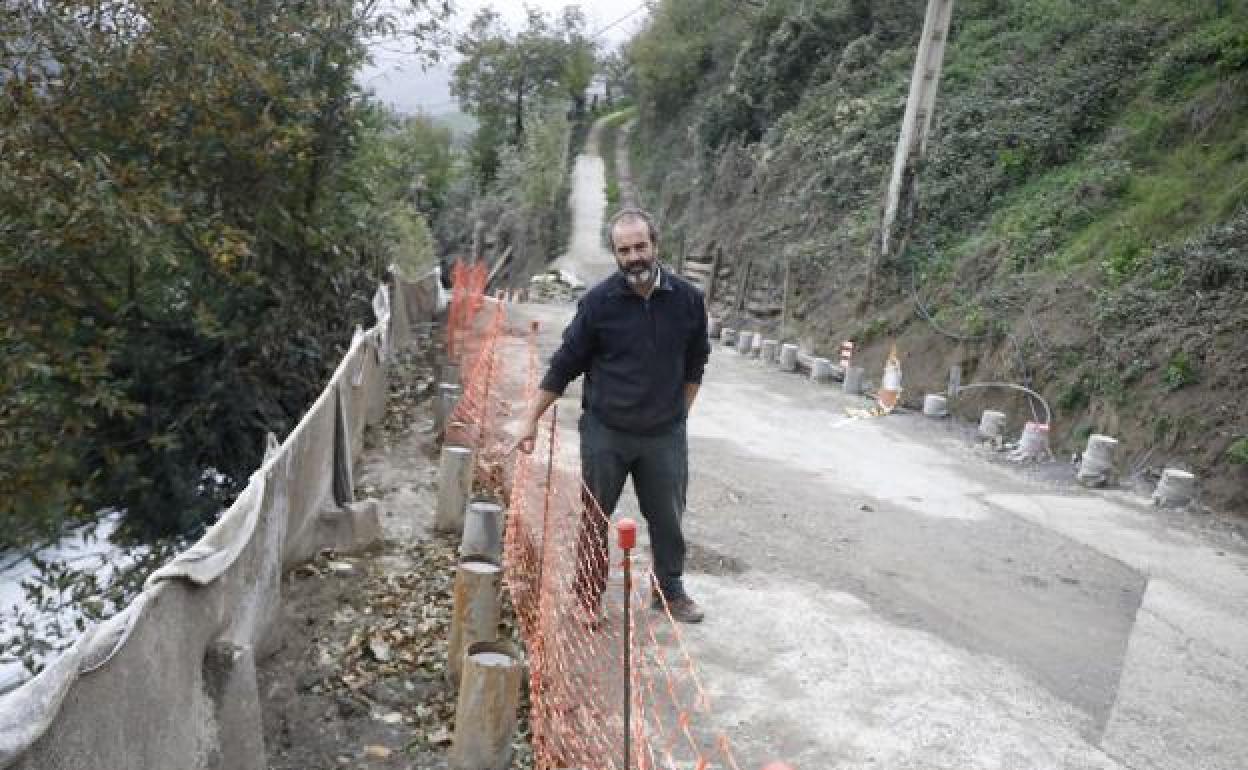 Un vecino de Cotorraso señala los pilotes para dar seguridad al muro que sustenta la ladera. 