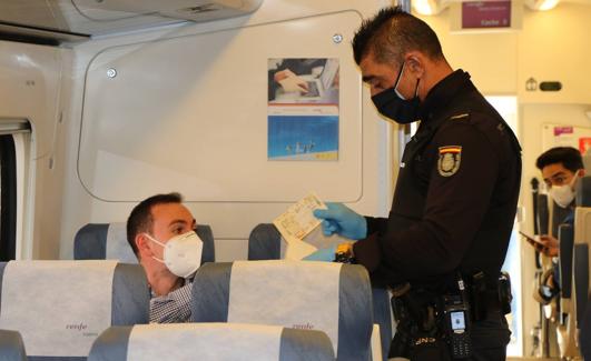 Un Policía controla este viernes el billete de un pasajero del tren León-Madrid. 