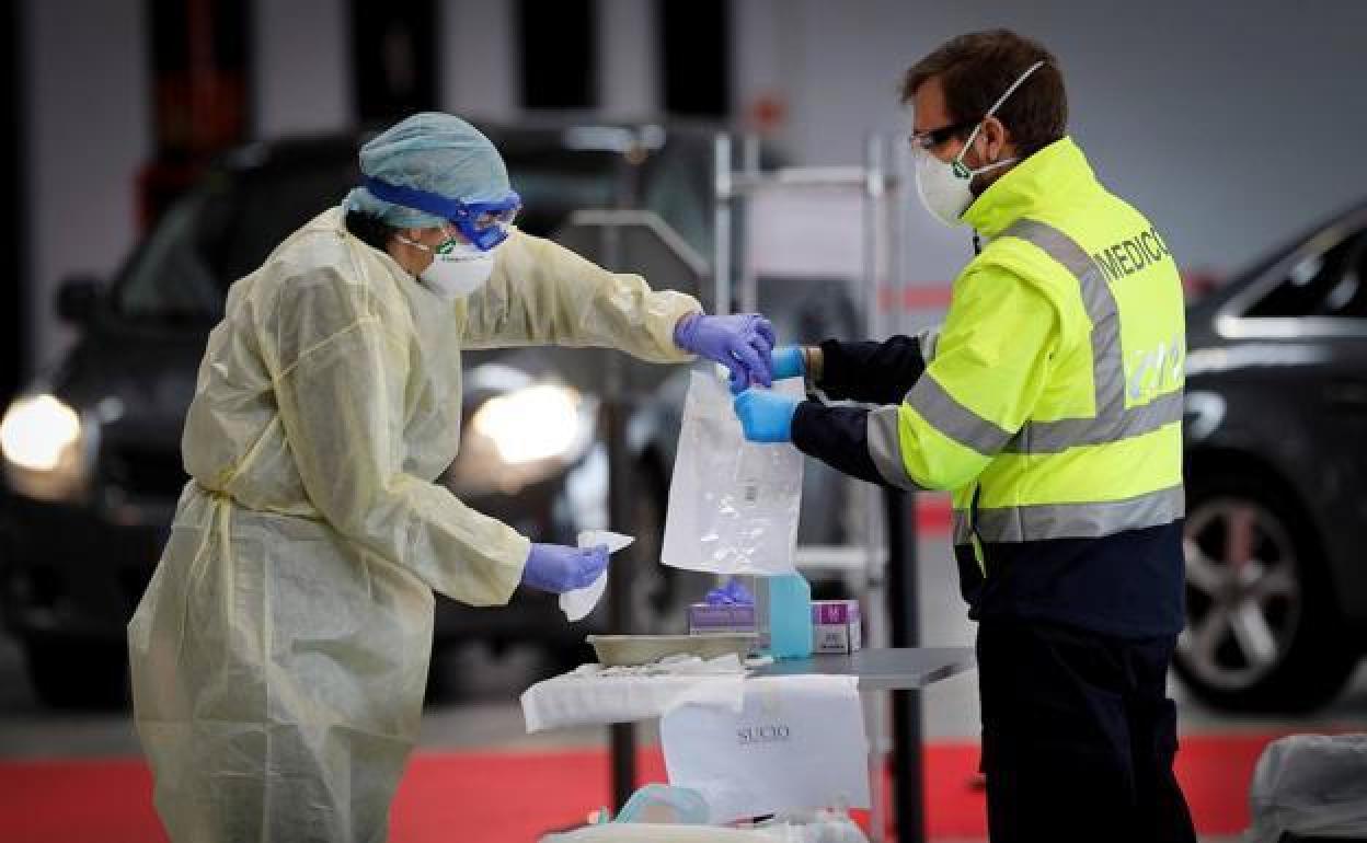 Dos sanitarios participan en la extracción de muestras para detectar nuevos positivos.