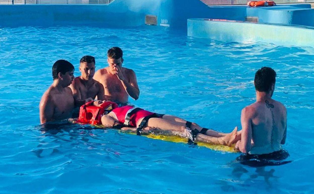 Voluntarios del programa de salvamento en una práctica de piscina.