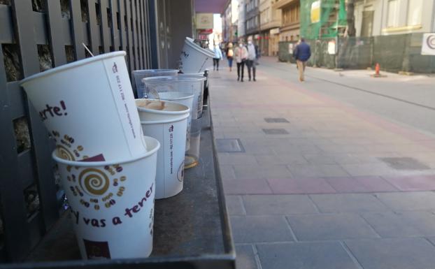 Vasos de cartón apilados en la puerta de un local de Burgo Nuevo. 