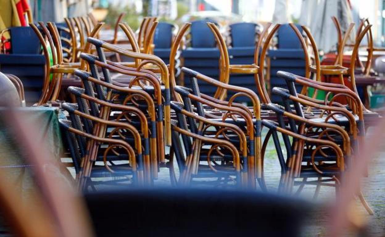 Sillas apiladas de una terraza que no se puede utilizar.