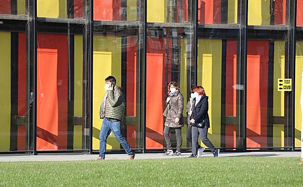 Imagen. Un grupo de personas llegan al Palacio de Exposiciones. 