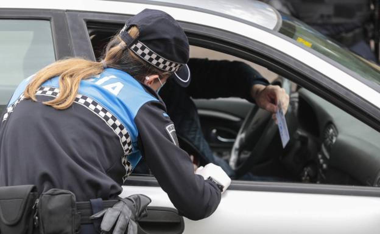 Una agente de la Policía pide la documentación al conductor de un turismo. 