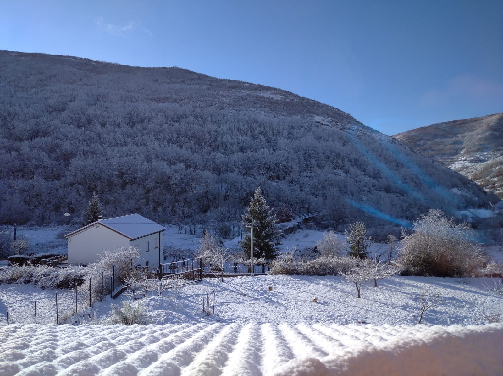 La nieve se apodera del entorno de la localidad en apenas unos minutos tras amanecer con un radiante sol.