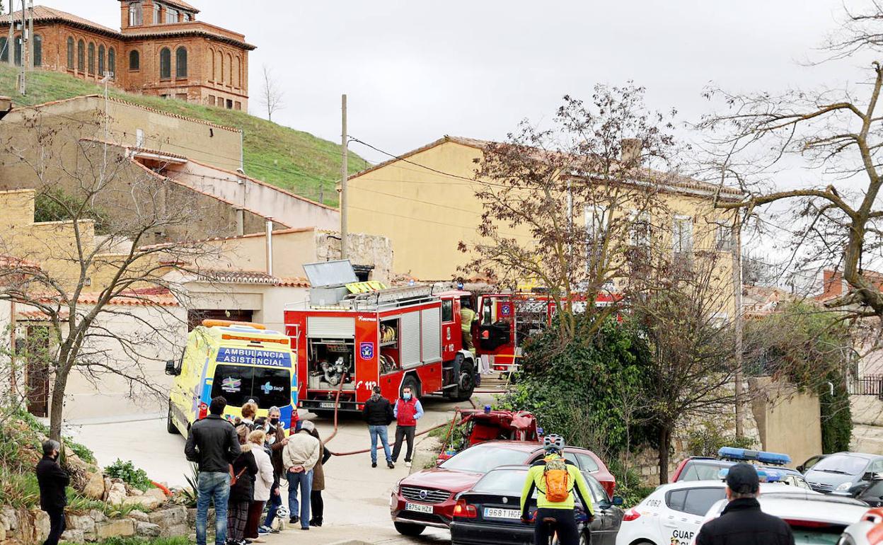 Los bomberos, dotaciones de la Guardia Civil y personal sanitario y curiosos, en el exterior de la vivienda.