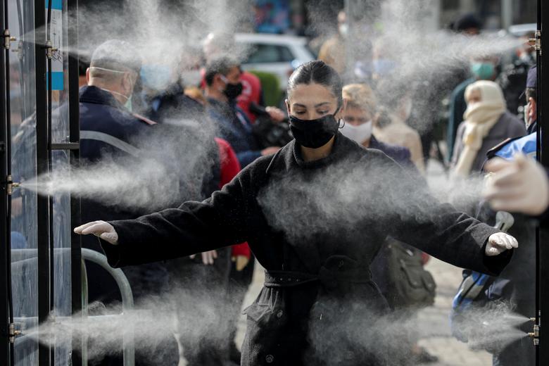 Albania | Una mujer, desinfectándose antes de entrar a un mercado, mientras las autoridades albanesas toman medidas para detener la propagación del coronavirus en Tirana, Albania.