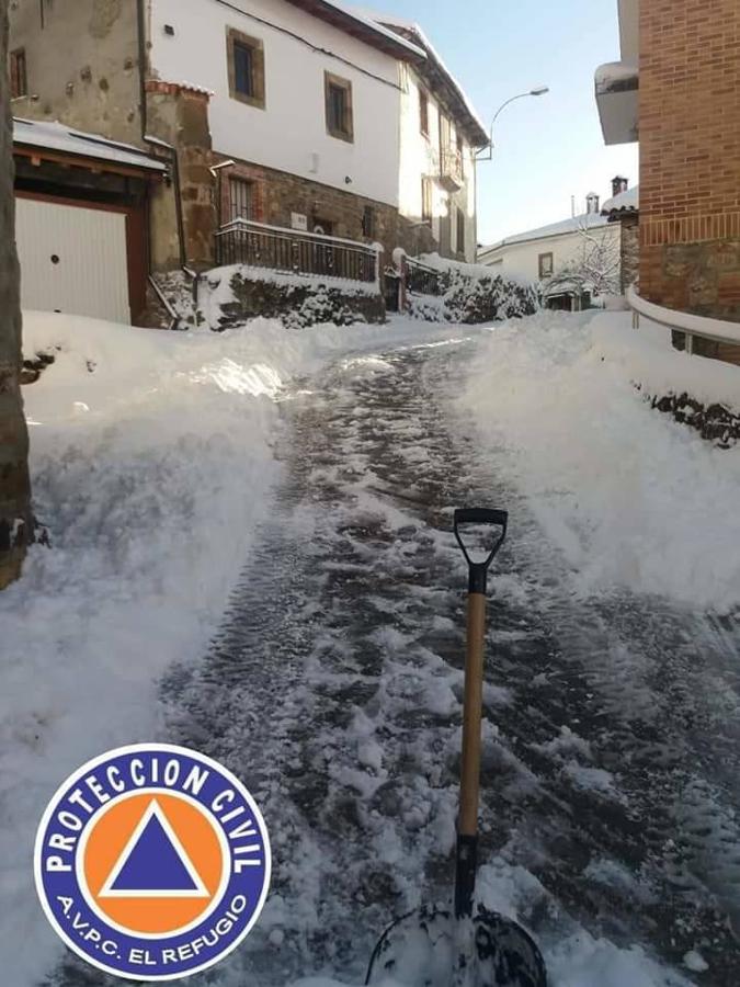 Los voluntarios de Protección Civil despejan la nieve caída en los últimos días en Ferreras del Puerto.