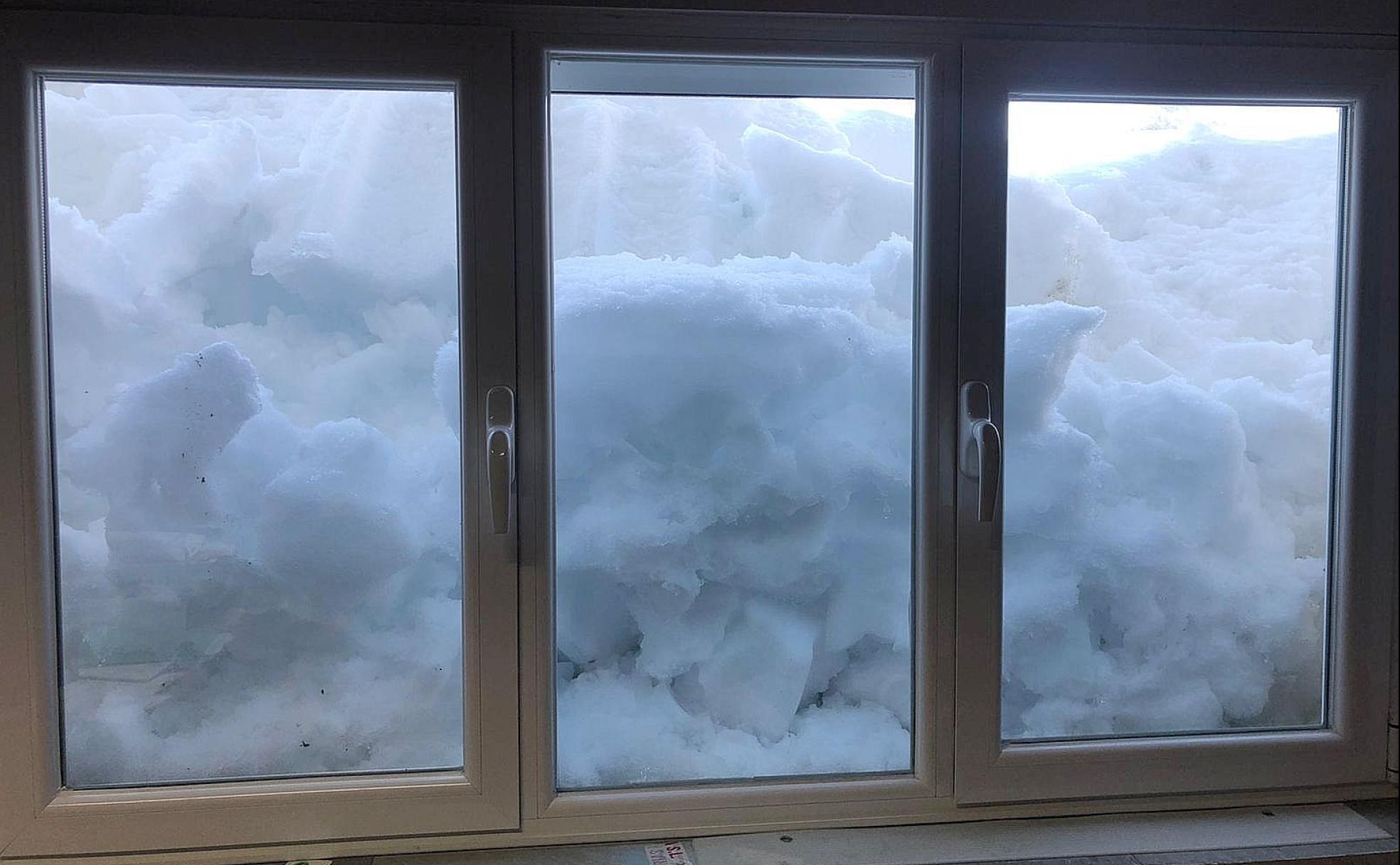 La nieve cubre un ventanal en la localidad leonesa de Posada de Valdeón.