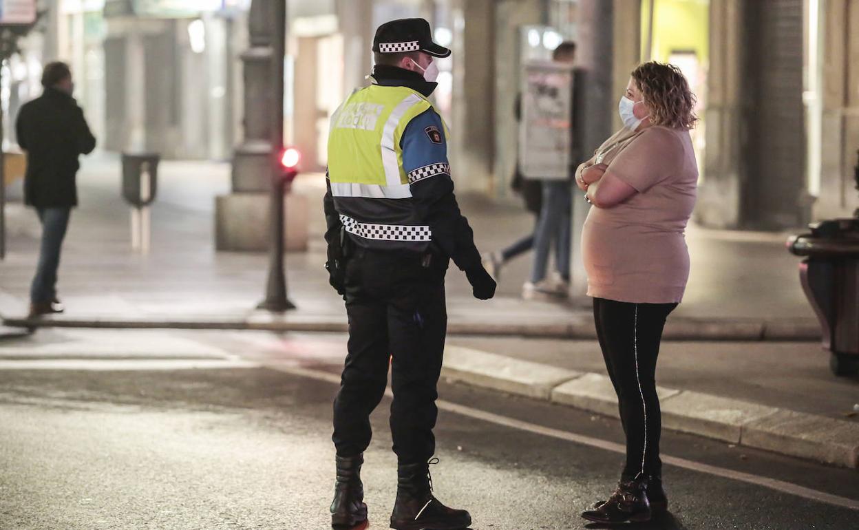 Un policía advierte a un ciudadano del toque de queda.