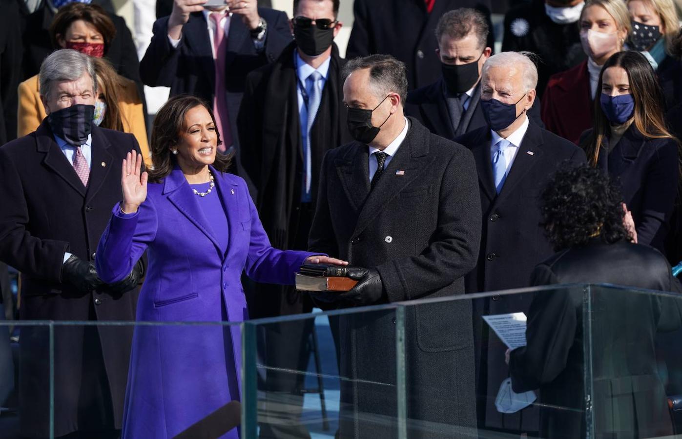 Kamala Harris presta juramento como vicepresidenta de los Estados Unidos mientras su cónyuge Doug Emhoff sostiene la biblia.