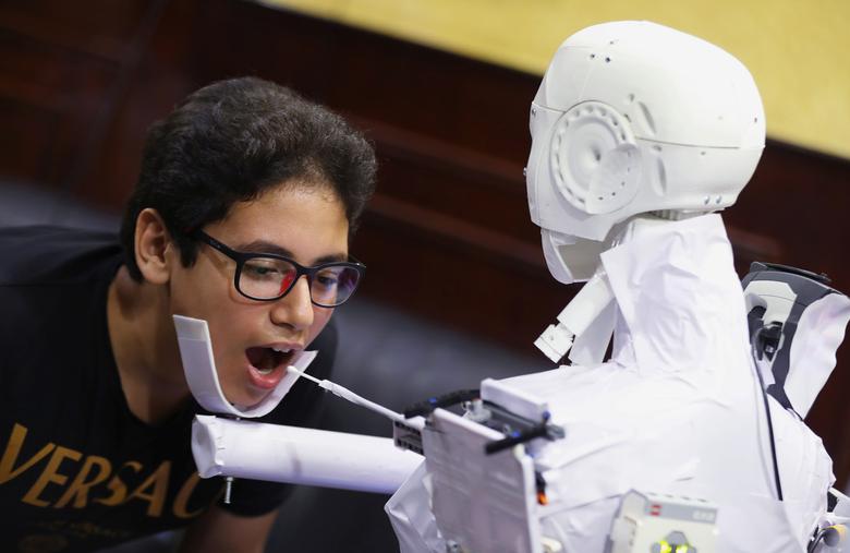 Un robot de control remoto que ha sido construido por el ingeniero mecánico egipcio, Mahmoud El komy, de 26 años, prueba a un niño para detectar el coronavirus realizando pruebas de PCR y limitando la exposición a casos sospechosos en El Cairo, Egipto.