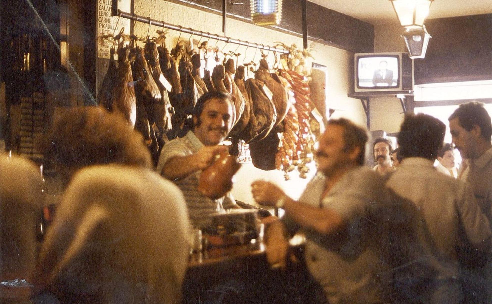 Miguel, sirviendo vino a granel, y rodeado de sus clientes en el Viña de Valdevimbre.