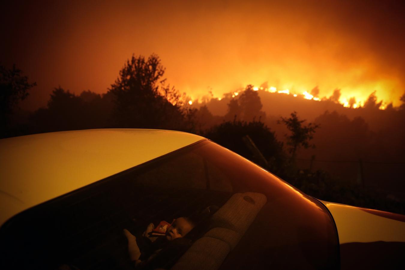 Un bebé refugiado en un coche frente a uno de los incendios que asolaron Portugal en 2021. Nominada en la categoría de fotografía individual de actualidad 