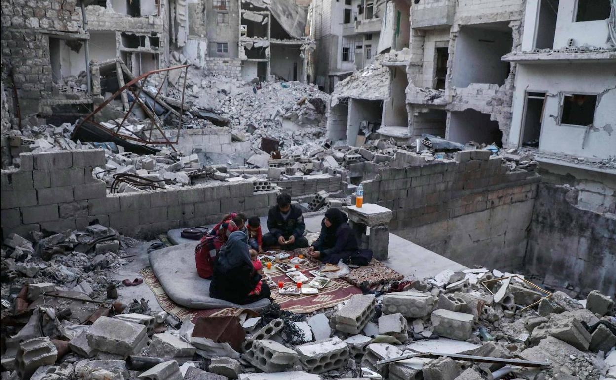 Una familia de desplazados siria celebra la cena del Ramadán entre las ruinas de Ariha.