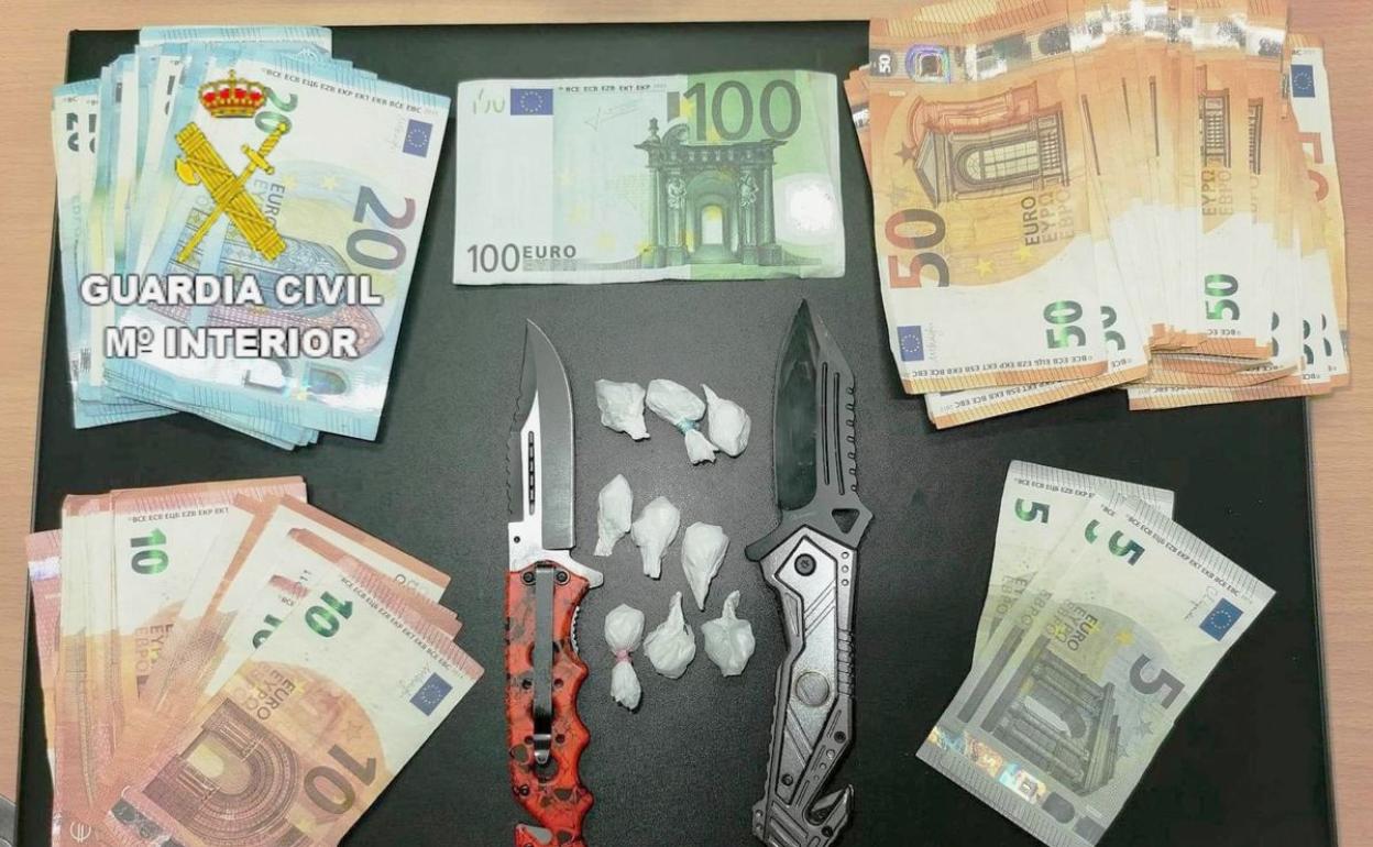 Imagen del dinero, cocaína y armas blancas incautadas por los agentes de la Guardia Civil.