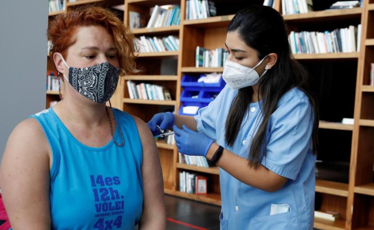 Una profesional sanitaria administra la vacuna contra la COVID-19 a una ciudadana en Barcelona 