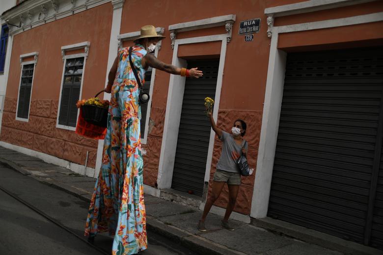 Anilson Costa regala flores a una mujer en el barrio de Santa Teresa.