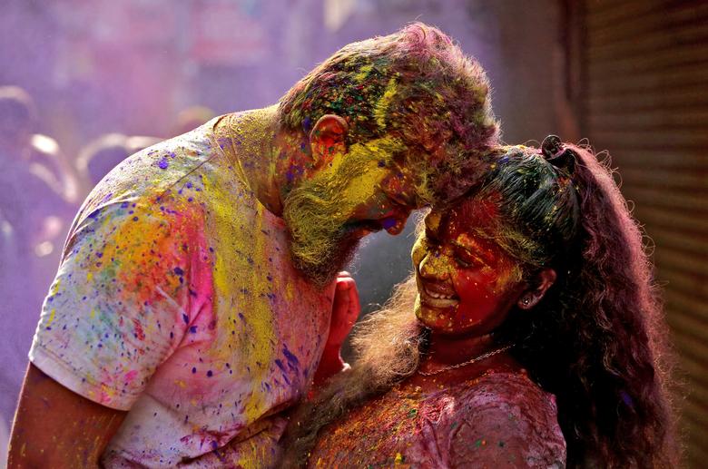 Una pareja embadurnada de colores reacciona cuando se les arroja polvos de colores durante las celebraciones de Holi en Chennai, India.