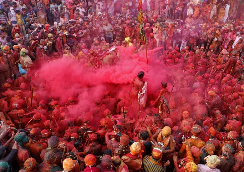 Hombres pintados de colores se arrojan polvos de colores durante las celebraciones de Lathmar Holi en la ciudad de Nandgaon, en el estado norteño de Uttar Pradesh, India.